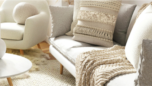 写真：白いクッションがあるグレージュのソファとテーブル