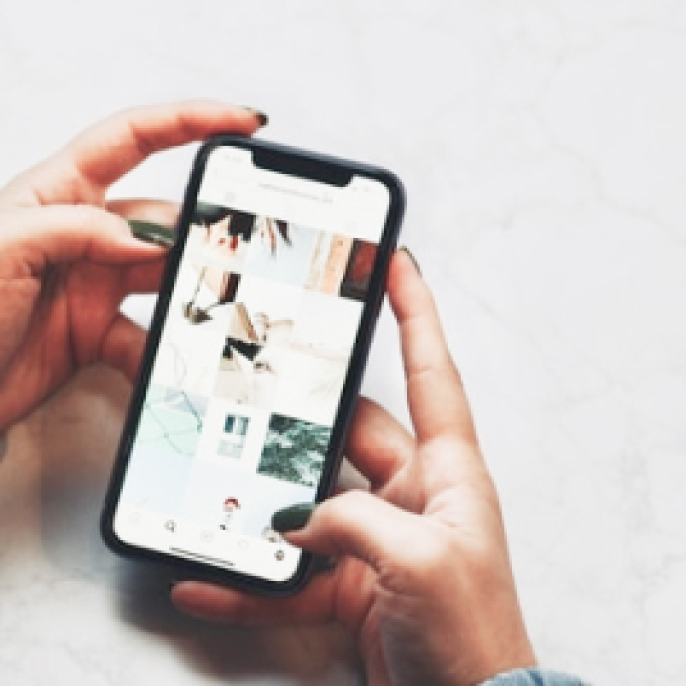 写真：両手に持たれたスマートフォン